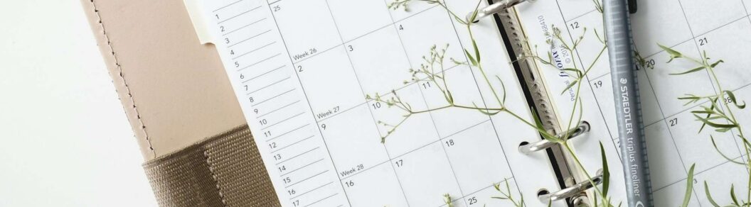 grey and black pen on calendar book